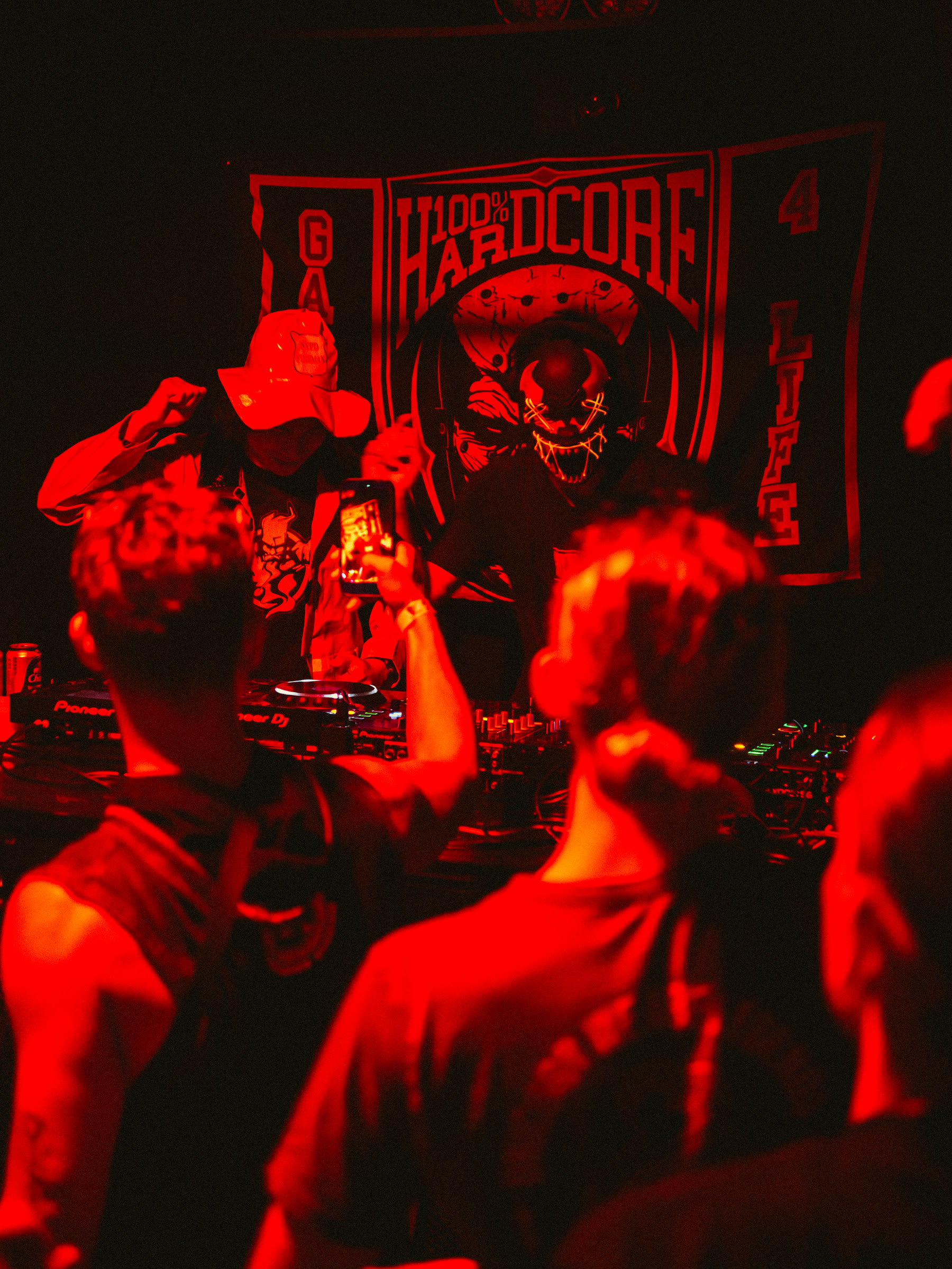 Masked performers behind the decks at Hard Signal
