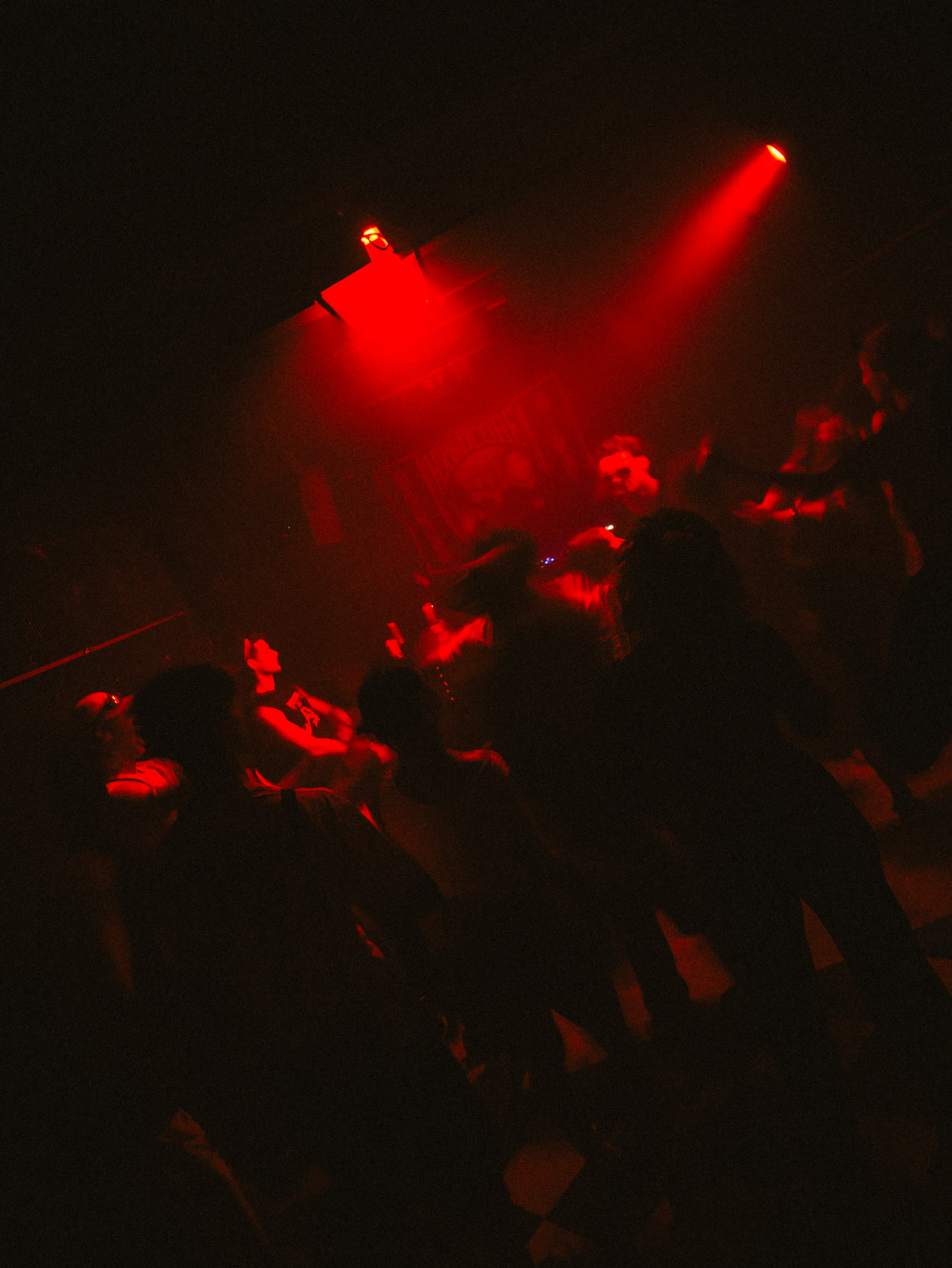 Hardcore dancefloor under red club lights